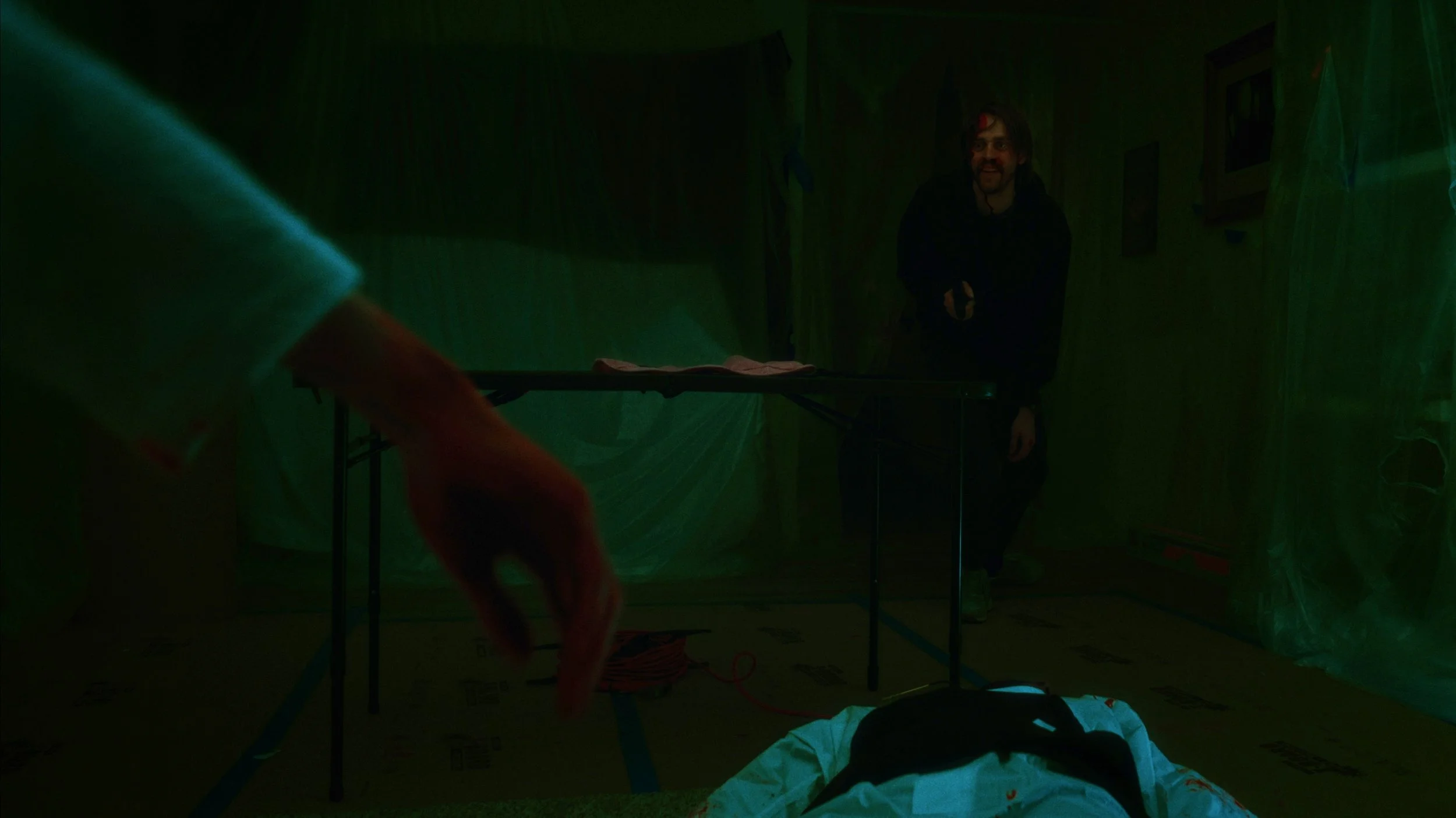 A dark figure standing in a room wrapped in plastic